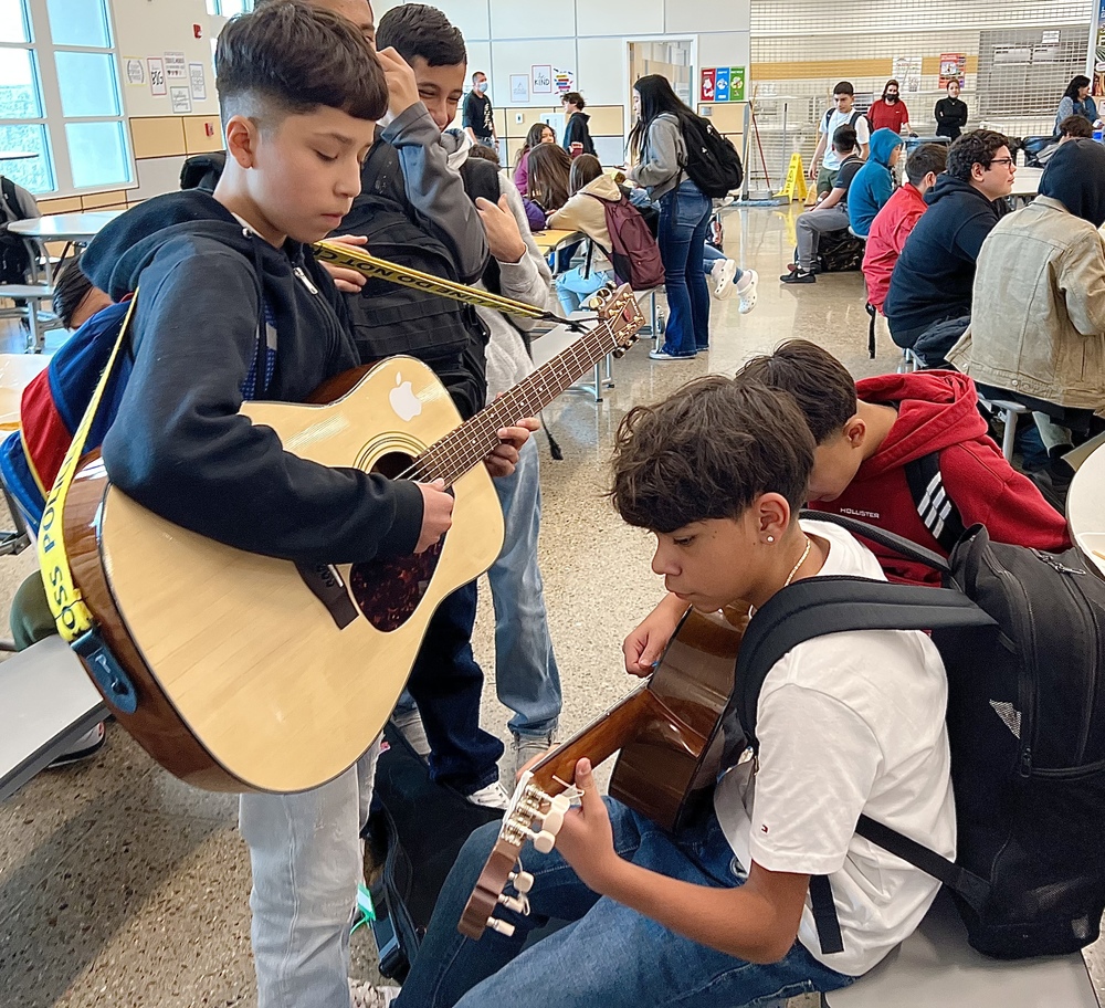 Milagro 7th graders practice guitar during lunch 