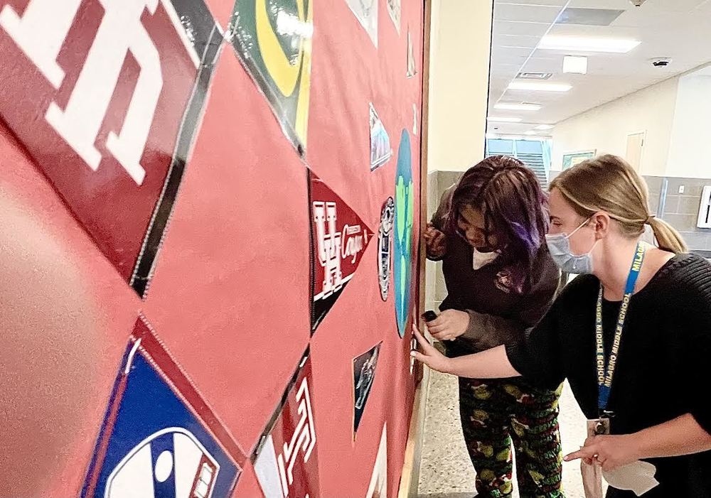 Ms. Pope adds college banners to the staff  display