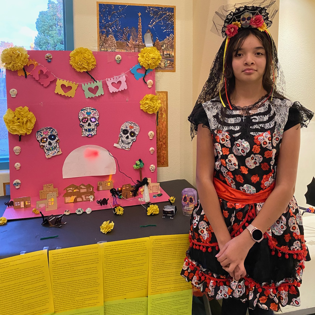 Student with Dia de los Muertos display