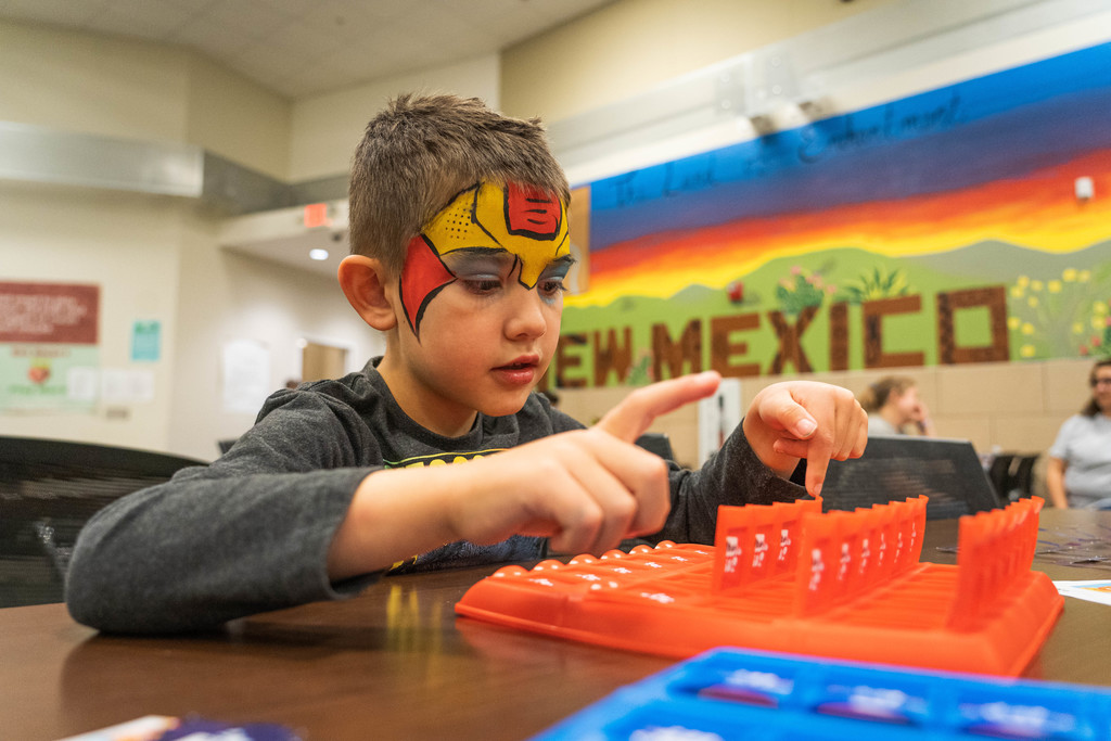 boy with iron man facepaint playing Guess Who