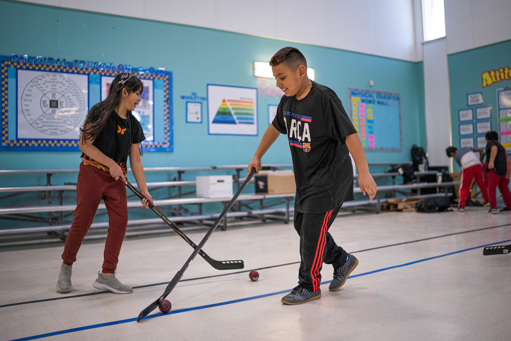 male and female 3rd grader stickhandling