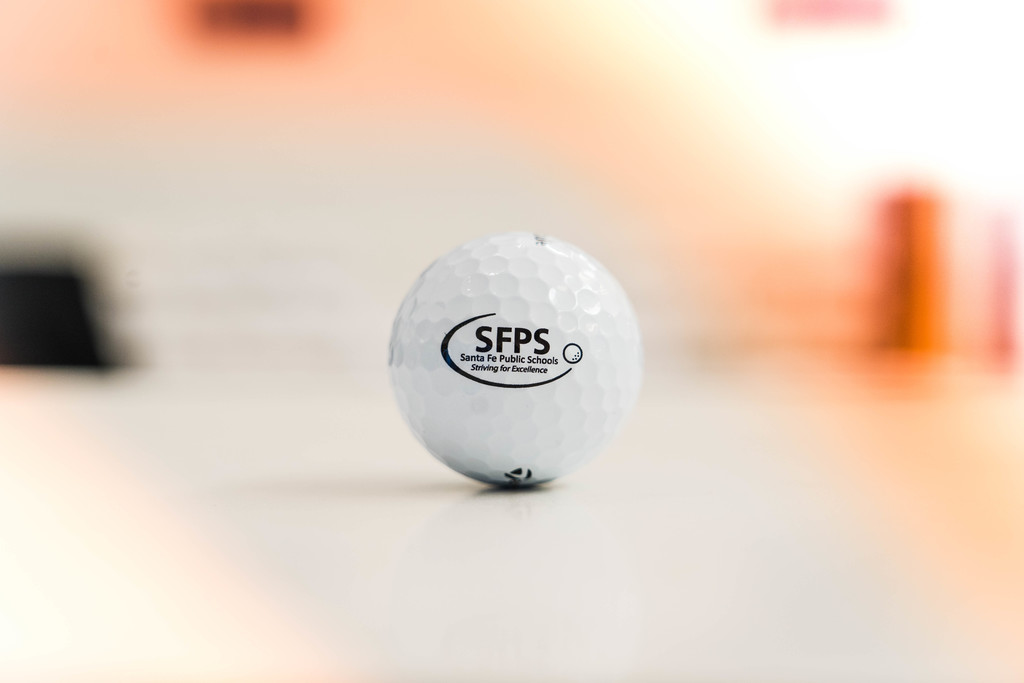 Golf ball with a black SFPS logo on it