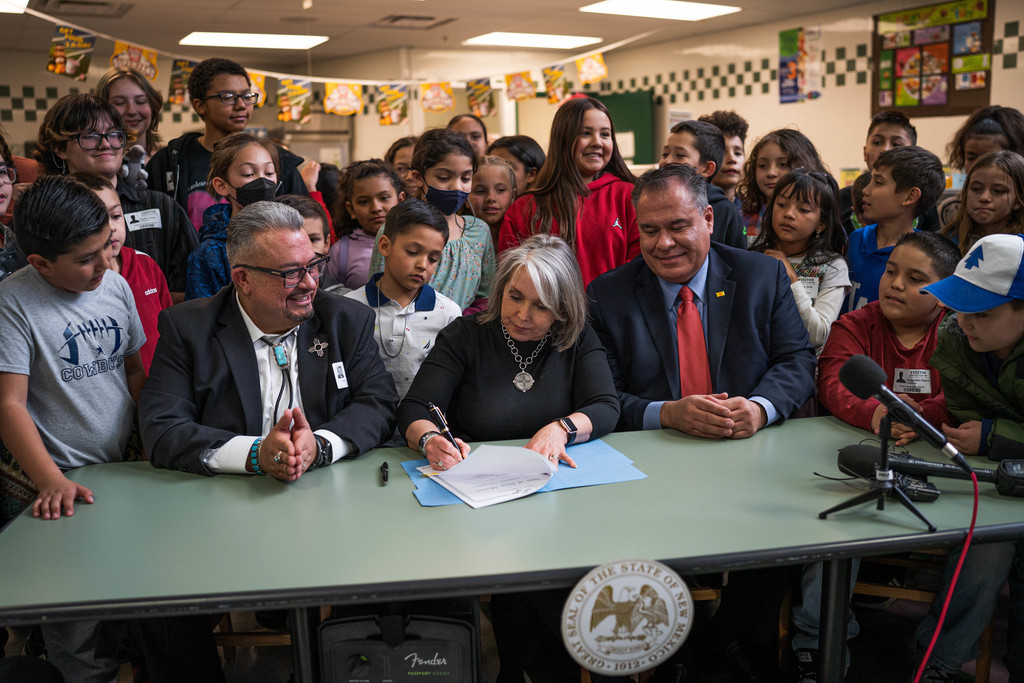 Governor Michelle Lujan Grisham signing SB4 surrounded my legislators and students
