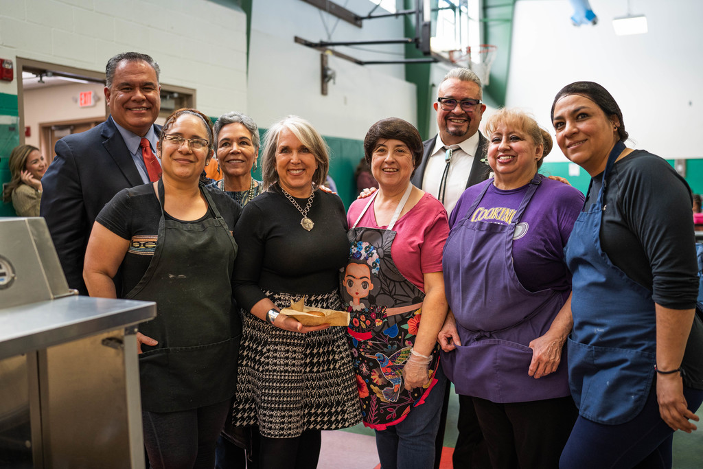 Governor Michelle Lujan Grisham standing with Pinon Elementary kitchen staff