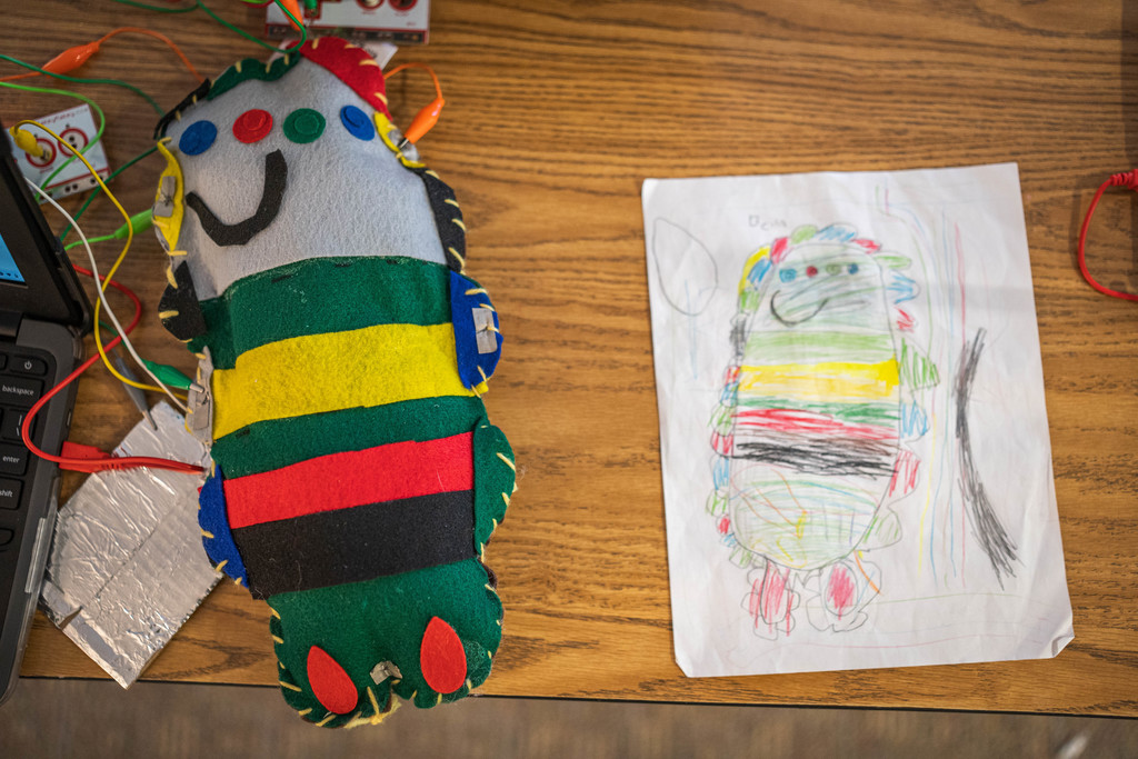 a multicolor felt monster next to an identical student drawing