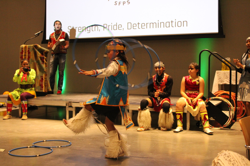 younger dancer performing with other dancers watching