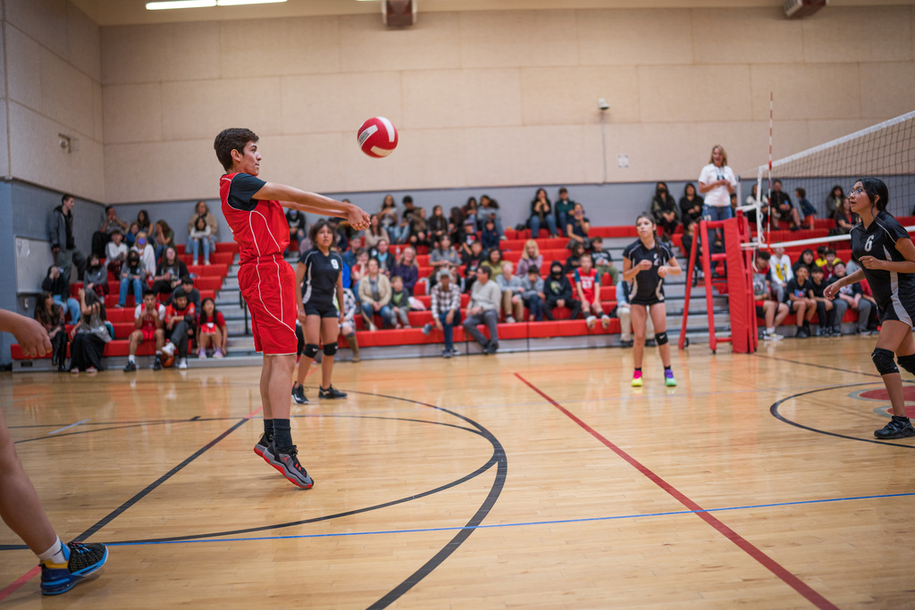 male student bumping a volleyball