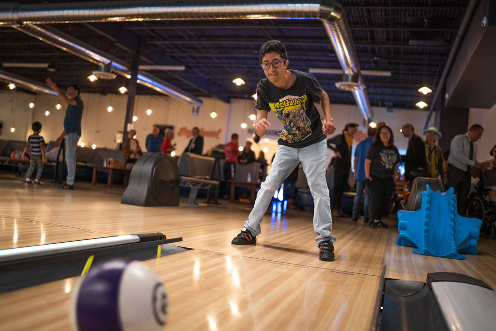 male student bowling with the ball going down the alley