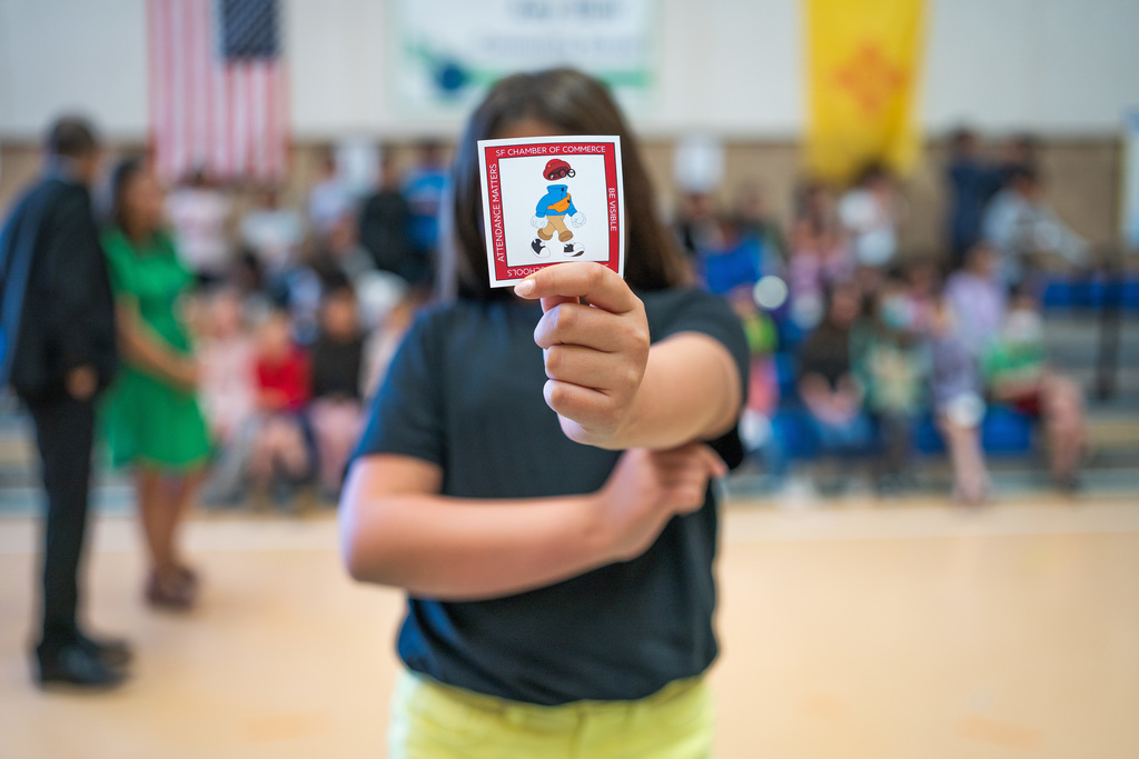 student holding up a sticker they received