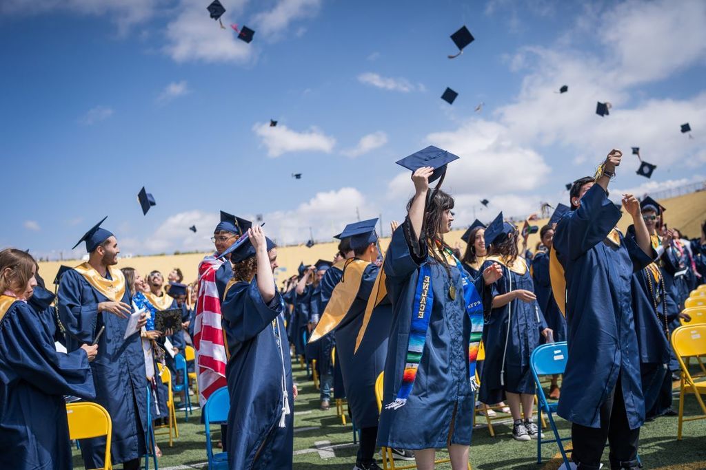 Students celebrating throwing their hats in the air