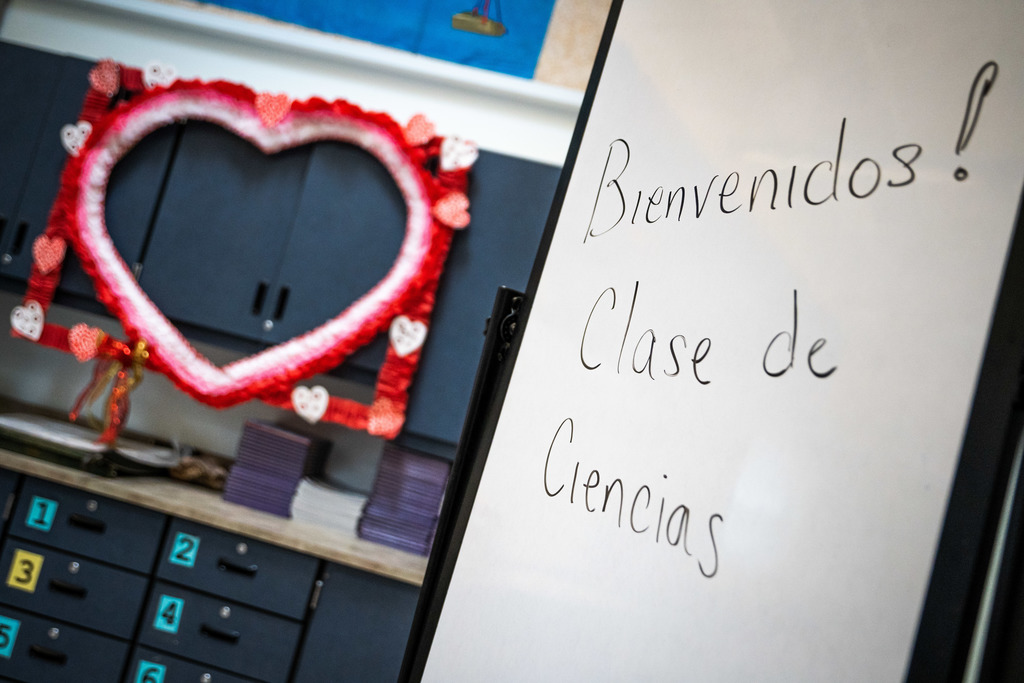 "Bienvenidos! Clase de Ciencias" on a whiteboard with a paper heart hung in the background